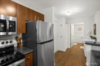 The kitchen features gorgeous dark wood cabinetry, granite countertops, and all stainless steel appliances. Breakfast bar offers additional seating. Dishwasher, range & microwave all convey.