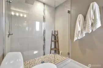 Enjoy taking a shower in this oversized shower with gorgeous stone tiles.