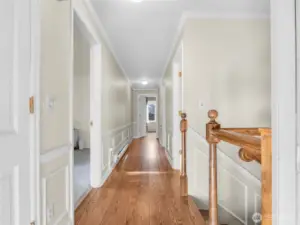 long, hallway with hardwood floors leading to the bedrooms/bathrooms upstairs and the lower level with additional, beds, bath, garage and mud room.