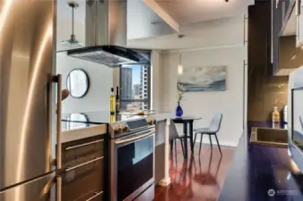 Another view of the open kitchen & wonderful overhead vent/fan for cooking.