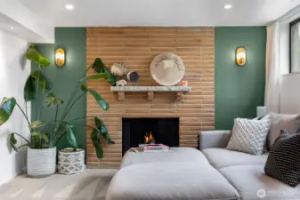 High ceilings and big windows frame the fireplace wall in the lower level living space.