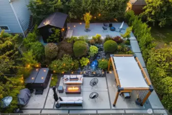 Full landscape renovation with hot tub, shed, outdoor power supply, grow beds, custom gazebo, waterfall, entry gates and light fixtures.