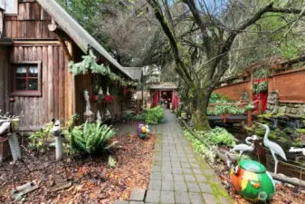 Looking across front of the home at Koi pond/bridge and gated entry to right. Garage is ahead in the distance behind the Gazebo.  All currently being used as part of the Christmas Shop at Timber Creek Active Business (for sale separately)