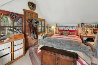 Upstairs bedroom with vaulted ceilings and balcony/deck