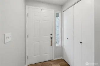 Front entry with updated vinyl plank flooring and paint. North-facing side windows provide consistent, soft, and, indirect light throughout the day. Spacious coat closet upon entry.