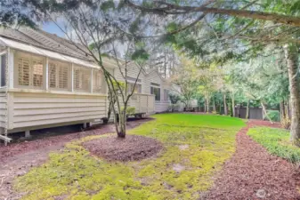 Sunroom and rear deck with views to trees and grass area.