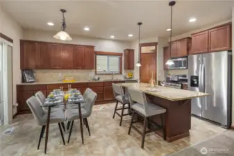 The dining area sits just off the kitchen island and opens to the patio through sliding glass doors—ideal for hosting and indoor-outdoor enjoyment.