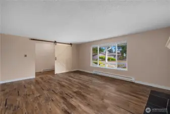 This bright living space showcases lots of natural light and a stylish barn door that adds charm while providing privacy when needed.