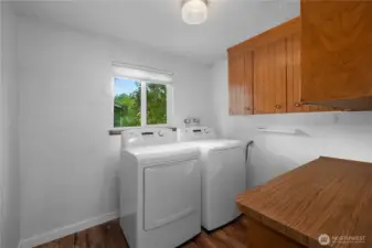 Laundry room offers generous storage and a convenient counter top for folding clothes.