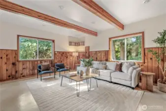 Another view of the family room. The wood walls and open beam ceilings make it feel like a lodge. Imagine all the fun you can have here! The two windows add light and offer beautiful views of nature.