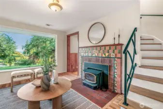 Charming tiled fireplace with wood stove and insert. If the power goes out you can still have heat from the wood burning fireplace. Enjoy views of the Cascade Mountains out the front window. Stairs lead up to the Primary Suite.