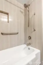 Bathtub in guest bath downstairs has ben updated with tile walls and fixtures.