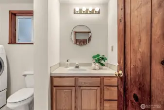 Downstairs Half Bath. The bathroom and W/D is conveniently located just inside the door, handy for cleaning up & washing after gardening or working in the yard.