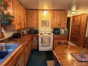 Attractive knotty pine cabinetry, broom & storage(linen)closets: with laundry shoot and door to the 3/4 bath/laundry room.