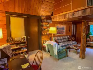 Another view of the living room with the door to the primary bedroom suite.