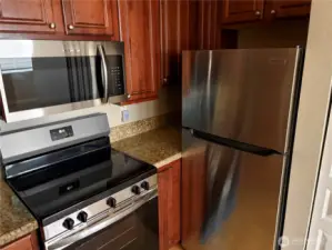 Stainless steel appliance suite including refrigerator, range, and microwave for a modern culinary experience.