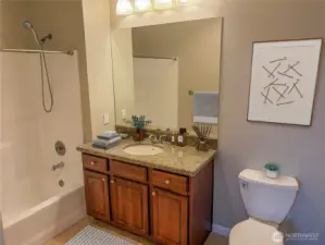 Bathroom with granite vanity, tub/shower combination, and clean contemporary finishes.