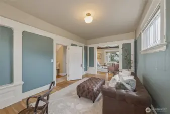Elegant sitting room showcasing classic millwork, hardwood floors, and beautiful leaded glass windows.