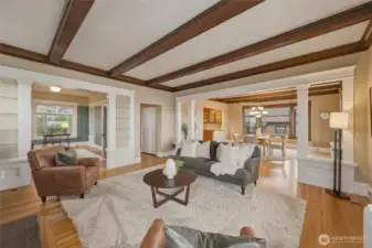 Beautiful living room anchored by a fireplace, rich wood millwork, and classic box-beam ceilings.