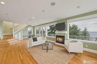 Daylight lower-level living space with gas fireplace, oak floors, and French doors to the deck