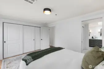 3-door closet in primary bedroom and closet designed by California Closets.  Additional 2-door closet in pass-through to bathroom.