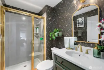 Second bathroom with shower, sink and toilet - discretely accessed in the hallway.