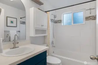 The full bathroom features ceiling height ceranic tile