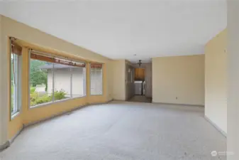 View from the dining area, through the living room is the front entry and laundry room beyond that.