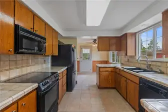 Kitchen features matching appliances, warm cabinetry, window above the sink, and room for eating space.