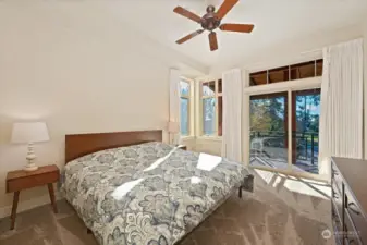 Very roomy primary bedroom with ceiling fan and patio sliders out to deck.