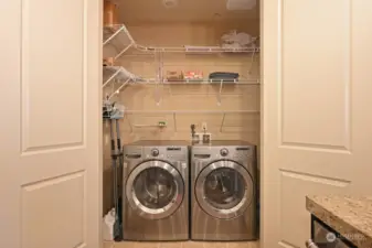 Laundry has a double door access to the super nice full size LG front loading washer & dryer with lots of shelving and room around it to store more.  The newer 2021 installed Bradford hot water tank is inside to the right unseen.