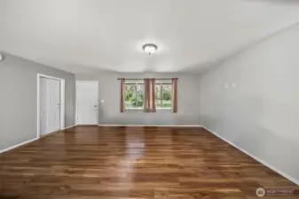 Living room with front entry and door to the attached garage.