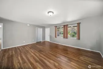 Living room with front entrance, door to the garage, and door to the primary bedroom is to the far left.
