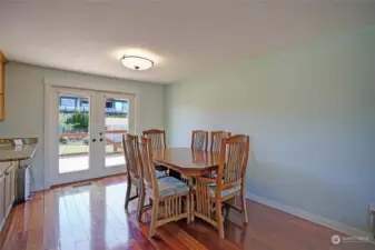 Large open dining space with south facing French doors to deck  and back yard keep the entire great room light and airy year round.