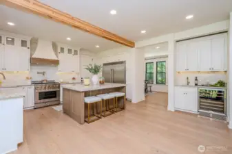 From the slider you have a great view of the gorgeous gourmet kitchen in all her glory! Stunning quartzite counters, large eat-in island with built-in microwave and tons of soft close storage drawers & cabinetry. High-end, professional appliances make cooking and baking a joy!