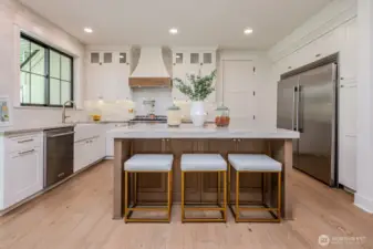 Love the custom cabinetry, the large farmhouse sink, the pot filler and the 60" Frigidaire Professional Refrigerator/Freezer with water dispenser & ice maker!  Extra pantry cabinetry flanks the fridge on both sides.  This is definitely a chef inspired kitchen! And imagine the view of kids throwing the football or jumping on the trampoline from the window above the kitchen sink!