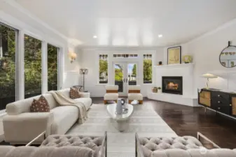 Surrounded by windows, the expansive formal living room captures natural light throughout the day. Enjoy the warmth of the gas fireplace in winter, or step through french doors to the balcony for fresh air and neighborhood views.