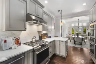 Oversized gas range with stainless hood.  Solid slab marble counters and backsplash walls.  Two ovens make holiday entertaining a breeze in this kitchen.  Large refrigerator and walk in pantry complete this kitchen.