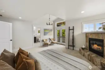 Primary bedroom with vaulted ceilings, gas fireplace, ensuite bathroom, and a very large walk out balcony complete with views.