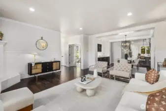 This impressive formal living room blends elegance with comfort, featuring a gas fireplace, French doors to the front porch, and abundant windows that frame the room in light.