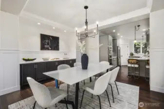 Dining space is perfect for entertaining.  Much larger dining tables can fit this space.  Tall ceilings with crown trim and wainscoting detailing along with custom built in storage.