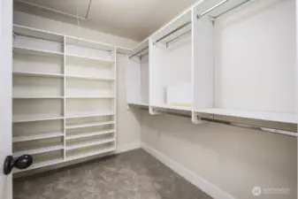 Primary bedroom walk in closet complete with storage organization.