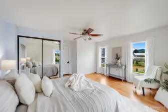 The main bedroom is bathed in natural light for a warm, airy feel.