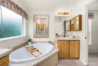 Primary bathroom includes two separate vanities, soaking tub, and shower.