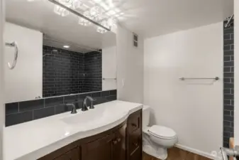 The coolest, retro bath. This well-appointed space has a large mirror, stylish light fixture and large vanity.