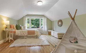Bright and spacious bedroom featuring a window box bursting with flowers and peaceful views of the tree-lined street.