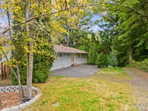 Back of the home. Pad could be used as a patio area or overflow parking. Access into the  mail level of the home.