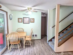 Dining room.  Hallway leads to the half bath on main, big office/den/optional 6th bedroom & garage.  Back yard through slider to the left.  Heading upstairs to the right.