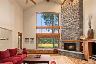 Great room with stone fireplace and tall windows to all natural light into the home