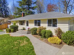 Inviting front entry with curved walkway, lush landscaping and large windows that fill the home with natural light.